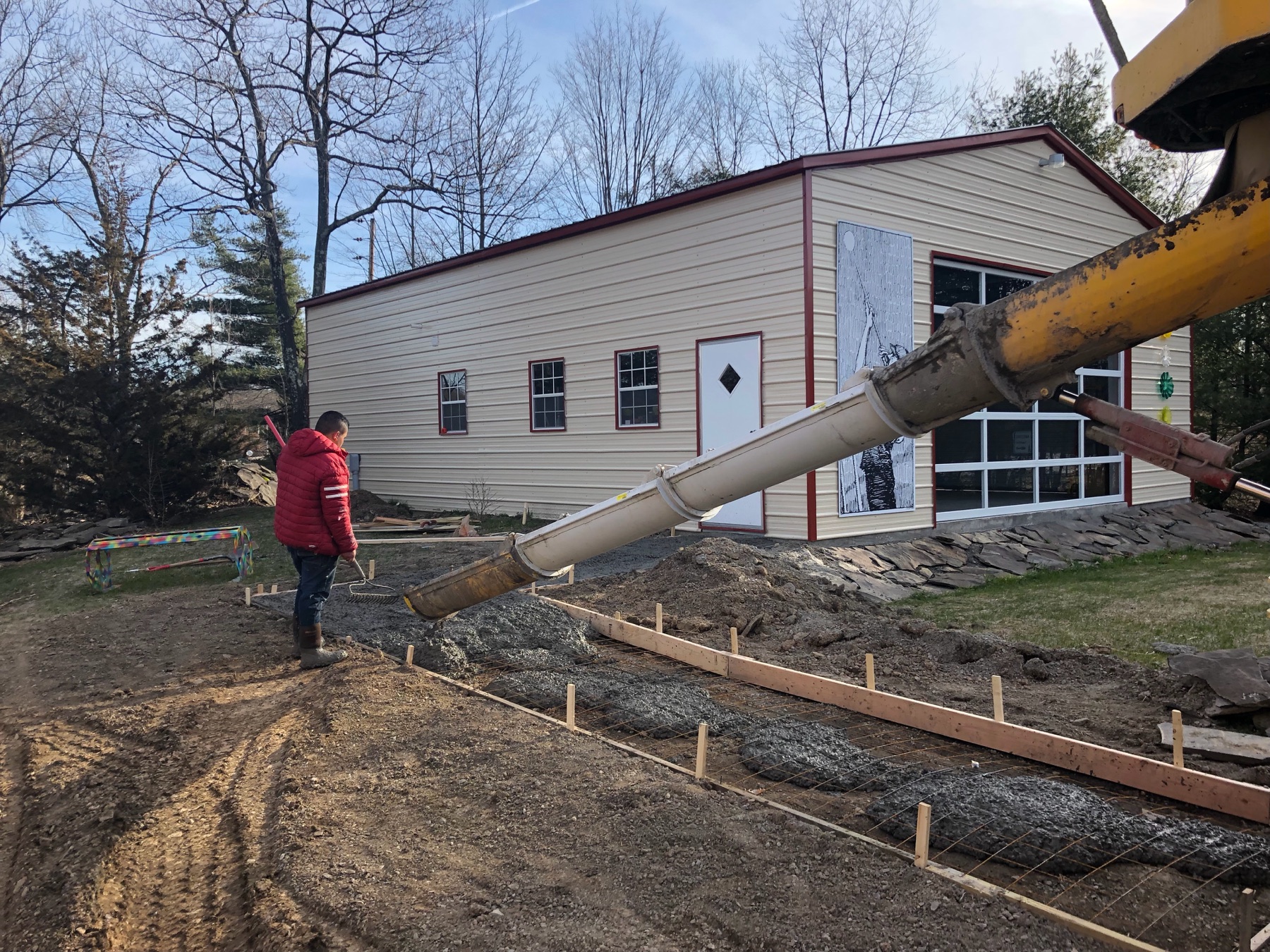 Cement sidewalk being poured beside a home