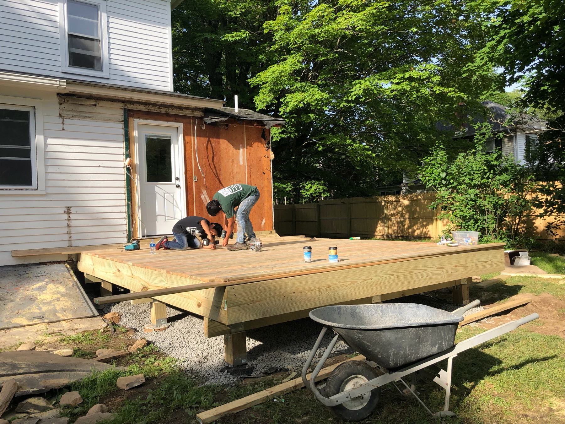 Deck framing and boards being installed behind a home