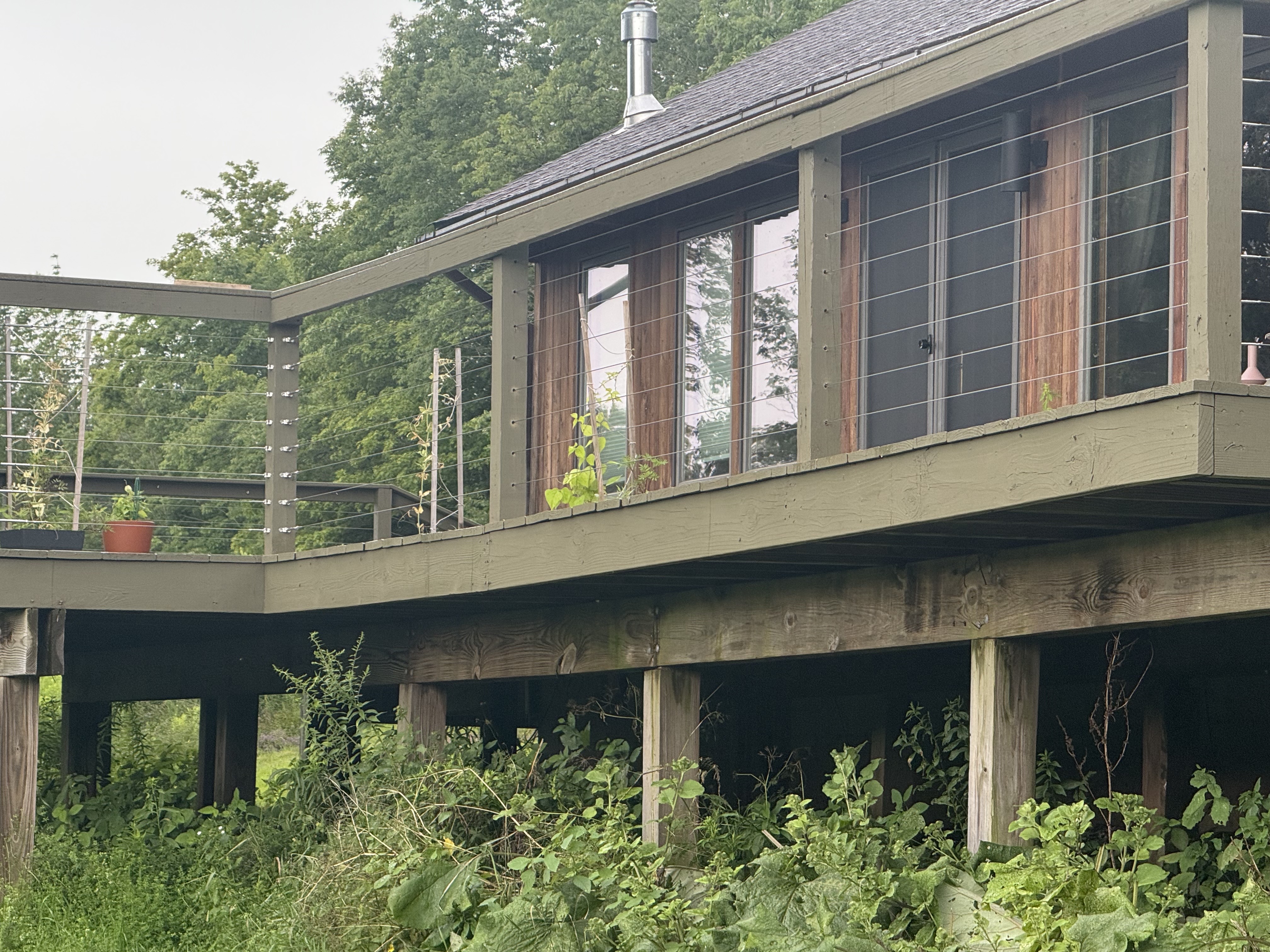 Raised deck with cable railing and wood siding detail
